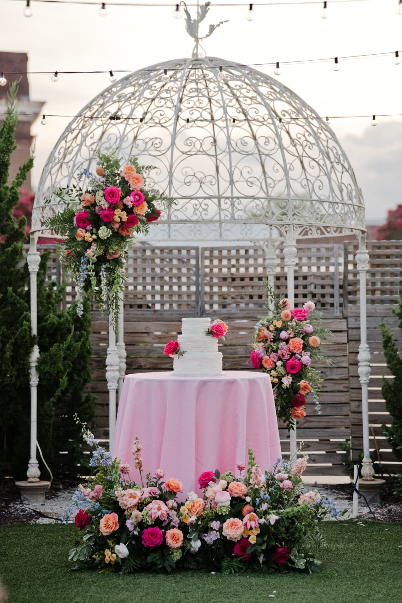 A wedding cake table framed by florals