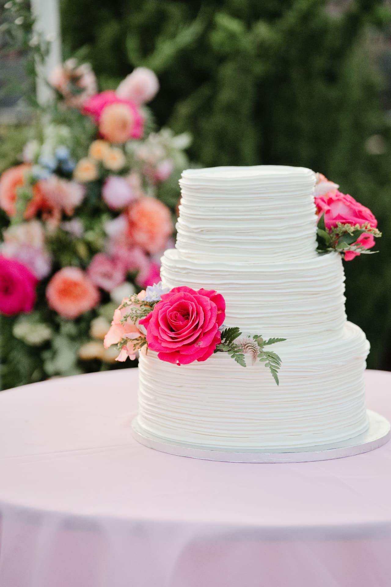A tiered cake decorated with bright flowers